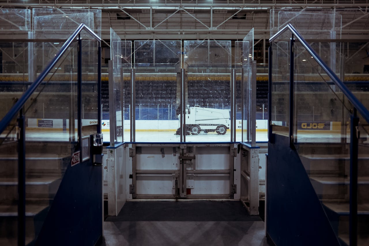 services-02 View of an ice resurfacer on an empty ice rink in a quiet sports stadium.